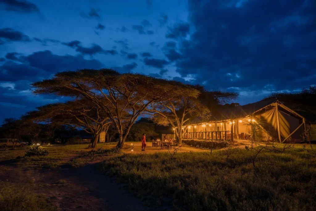 Illuminated safari camp at dusk following Tanzania safari safety tips after dark.